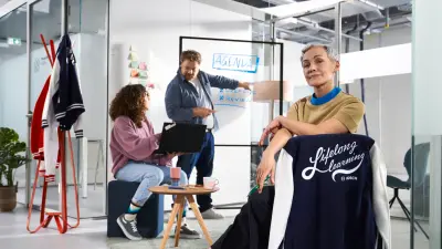 Dois associados a jogar matraquilhos com um robô de assistência Bosch Rexroth APAS.