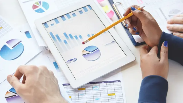 folha com graficos e dados e pessoas analizando