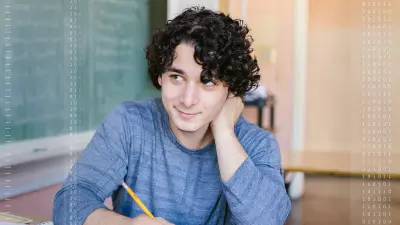 A student sits smiling in a classroom, ready for creative learning.