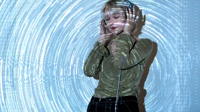 Woman with closed eyes wearing headphones, surrounded by digital light patterns.