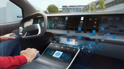 Uma pessoa está sentada em um carro usando uma tela sensível ao toque. Partes do painel estão cobertas por blocos de pixels coloridos.