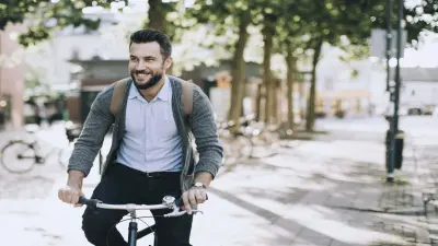 Homem se locomovendo de bicicleta pela cidade