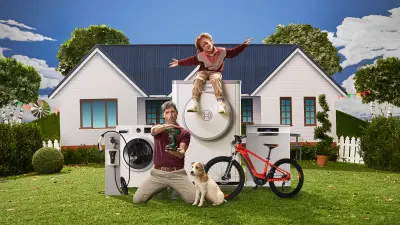 Homem segurando uma ferramenta da Bosch no jardim de uma casa, com a presença do seu filho e animal de estimação